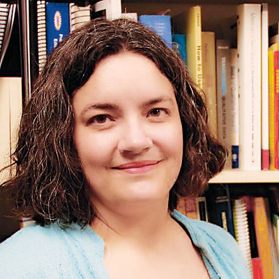 Profile head shot of Stacey Hust in front of a bookshelf