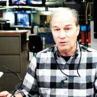 Bill Swartz talks and gestures in the production area of KOMO News