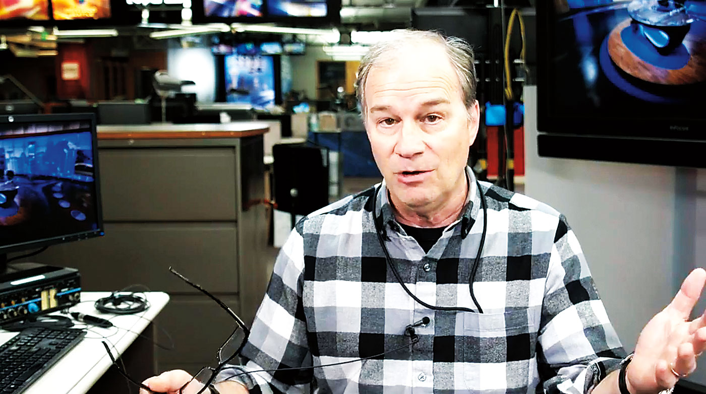 Bill Swartz talks and gestures in the production area of KOMO News