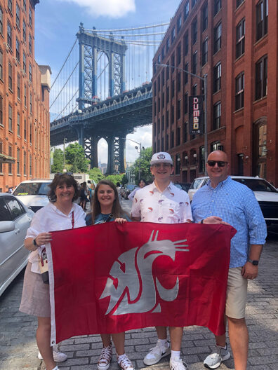 Family of four with a WSU flag in a city