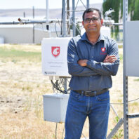 Man stands in front of WSU weather monitoring tower