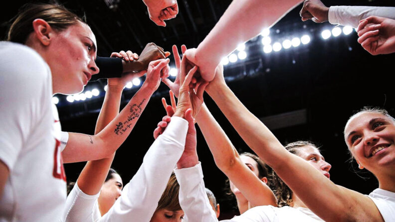WSU women basketball team members with hands together