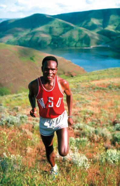 Man runs up a hill above a river