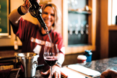 Woman pouring red wine into a glass