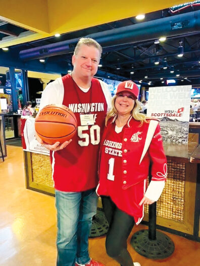 Tall man holding a basketball next to a woman in baseball cap, both wearing WSU clothes