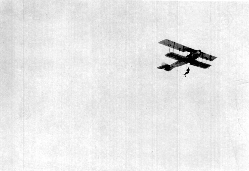 photo of Clyde Edward Pangborn hanging from biplane