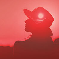 Outline of woman in a hat in a red tint. Derivative from photo illustration by Max Che