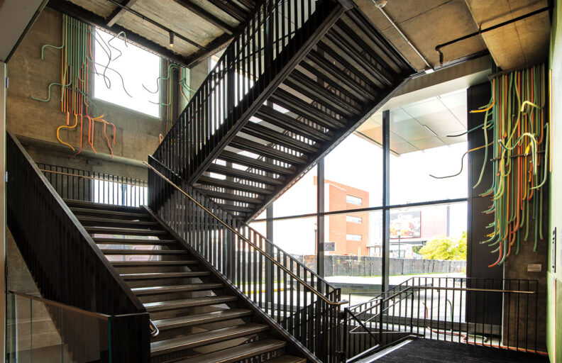 Colorful tubes down a staircase wall