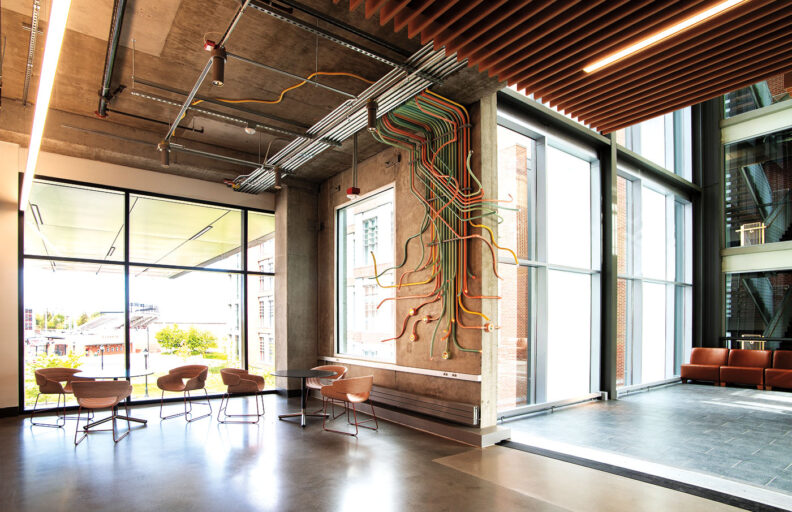 Colorful tubes go down a wall and over windows in art installation