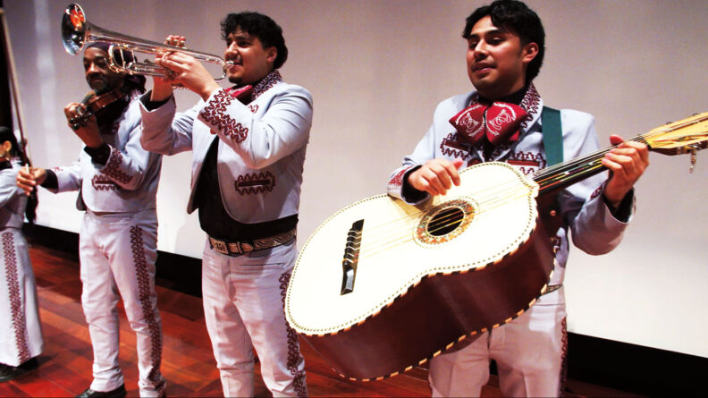 Men playing guitar, trumpet, and violin in traditional mariachi
