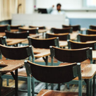 Empty college classroom with many wooden lecture chairs but no students. Edulife Photos