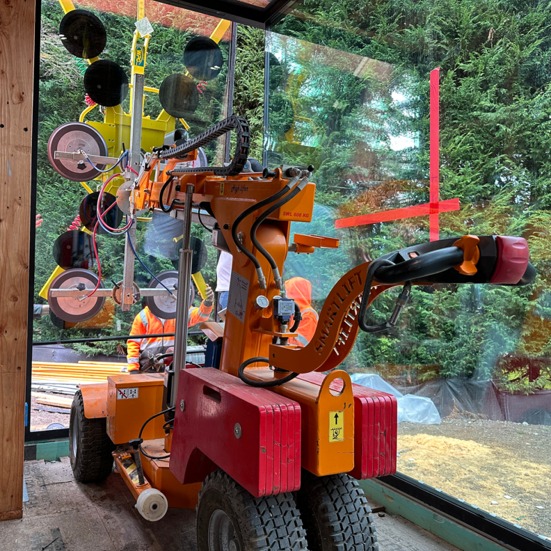 small crane moving a glass doors