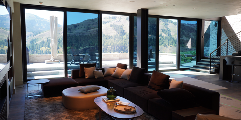 Living room with large glass doors facing hills and forests