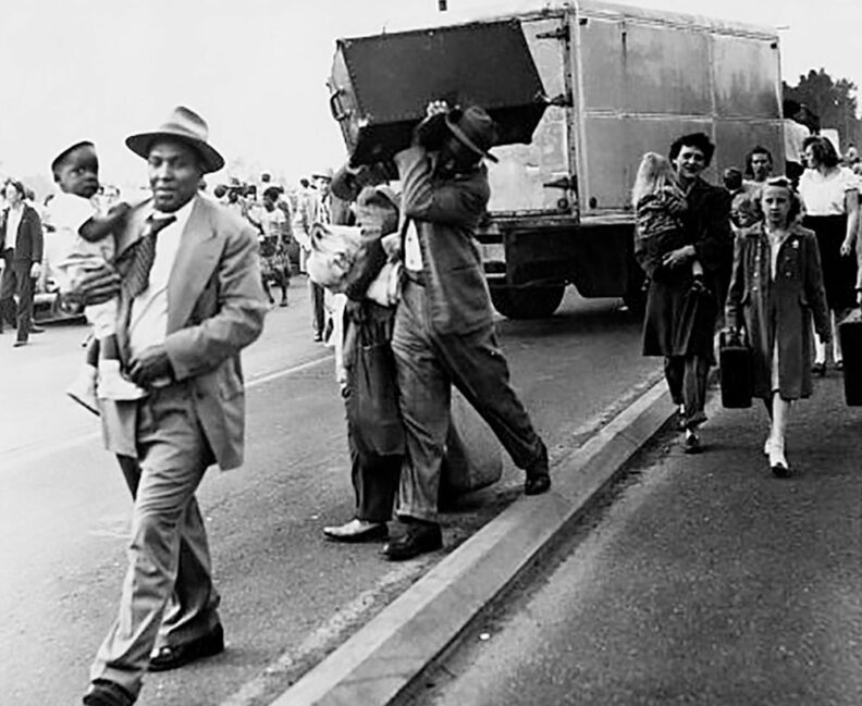 People from Vanport, carrying children and luggage, being resettled in 1948 after the flood