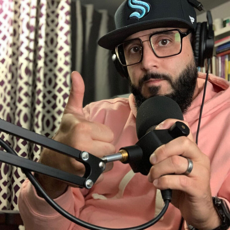 Johnny Lupinacci in a soundbooth with mic gives thumbs up