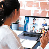 Woman talks with a group via videoconferencing