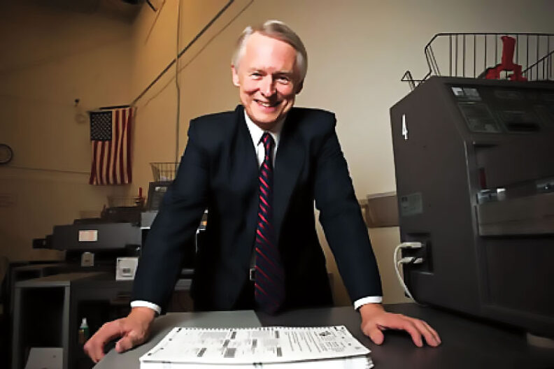 Washington state's secretary of state Sam Reed stands above pile of ballots