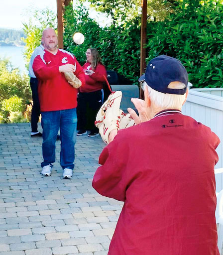 Two men wearing WSU clothes play catch with a baseball