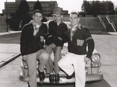 Vaughan Hitchcock, Bill Tomaras, left to right, leaning on hood of car