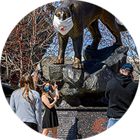 student selfies at the masked Cougar Pride sculpture