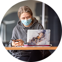 masked student with laptop