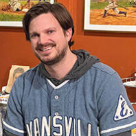 Profile of a smiling, bearded young man with dark hair in Evansville baseball shirt. The background has illustrated baseball pictures.