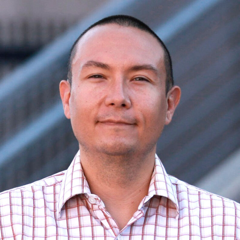 Closeup of an Asian man with close-cropped hair and a plaid shirt