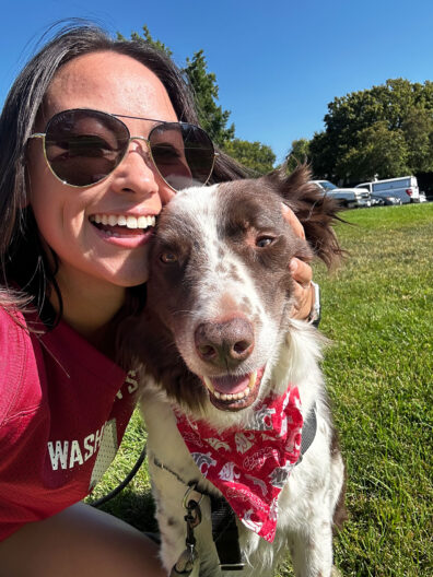 Young woman in sunglasses with a dog in a park