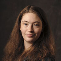 Headshot of a smiling young woman with long brown hair