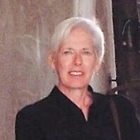 closeup of an older woman with short gray hair and black shirt