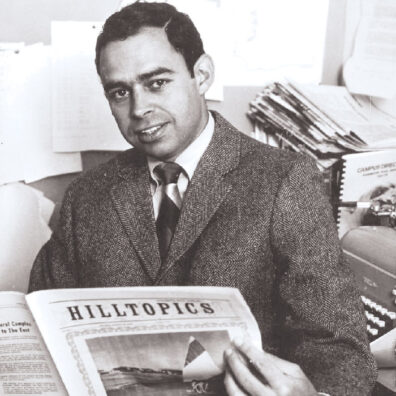 Black and white photo of Pat Caraher in a suit hold WSU alumni publication Hilltopics