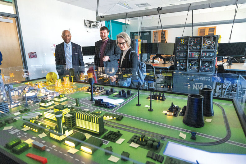 WSU President Elizabeth Cantwell and WSU Everett Chancellor Paul Pitre look at a model of the electrical grid in a laboratory and classroom.