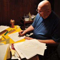 Ken Struckmeyer sketches at a desk
