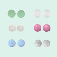 Different colored pills on a light blue-green background