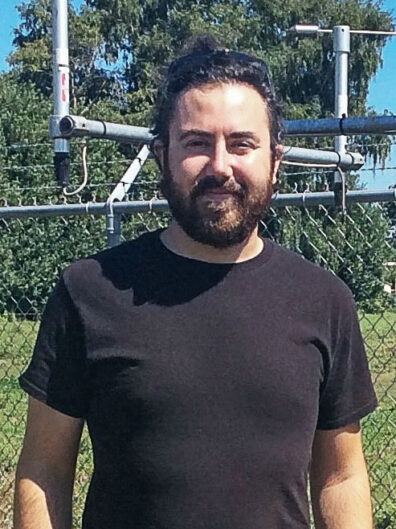 Man in front of outdoor scientific equipment