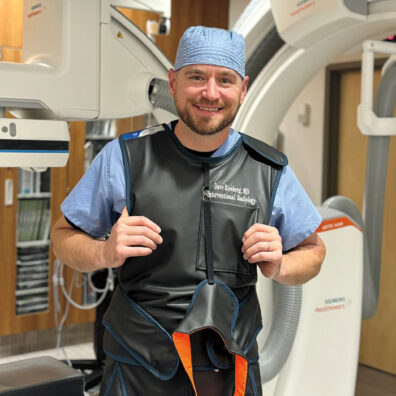 David Riesberg in medical scrubs and a protective vest for radiology