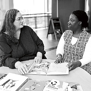 Stacey Hust at a table talking to a student