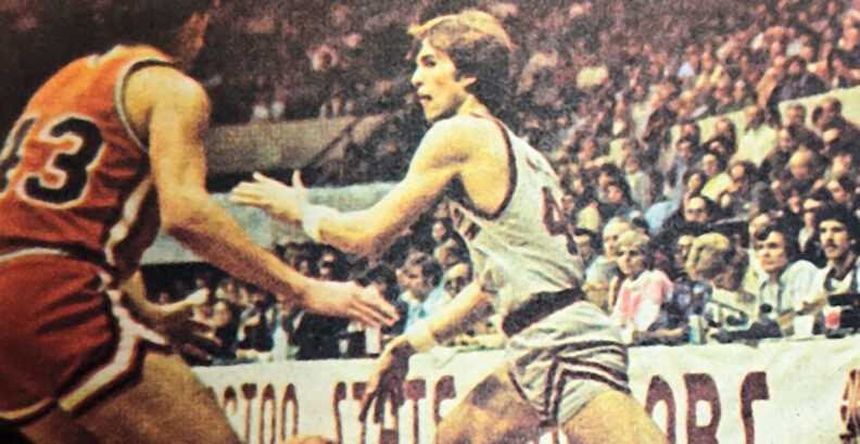 Man throws basketball past an opponent