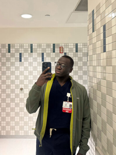 Joel Bervell in a tiled room shoots a video on his phone