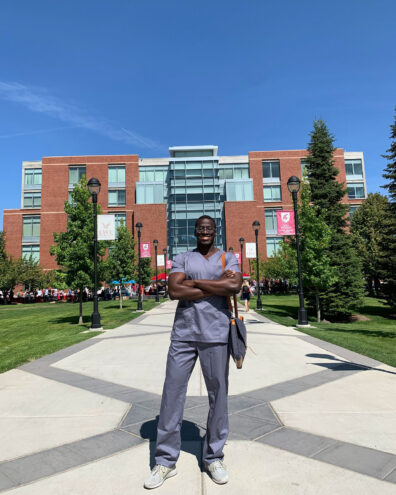 Joel Bervell in medical scrubs on the WSU Spokane campus