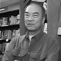 Black and white headshot of Alex Kuo in front of bookshelves