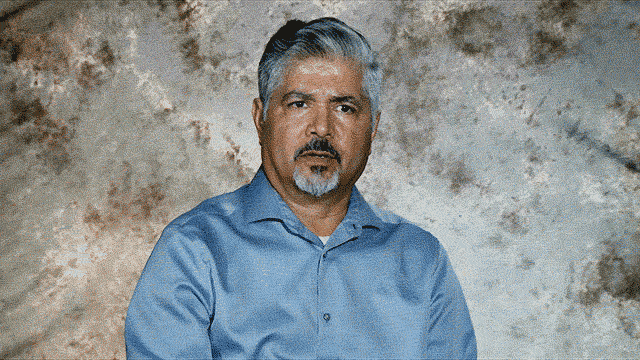 Ruben Peralta in blue dress shirt talking