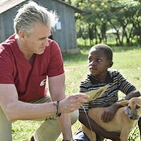 Guy Palmer with a Tanzanian boy and his dog