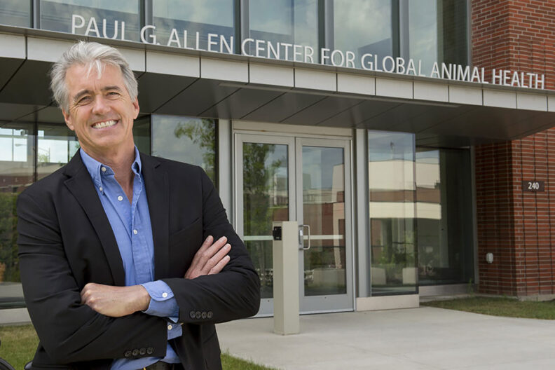 Guy Palmer smiling in blue shirt and dark suit jacket in front of the WSU Paul G. Allen Center for Global Health