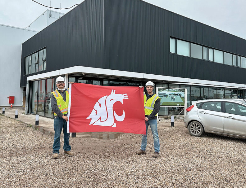 Esteban Mena-Salgado and Anthony Bonilla hold a WSU flag in Argentina
