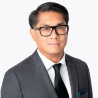 Ben Santos in glasses and a gray suit