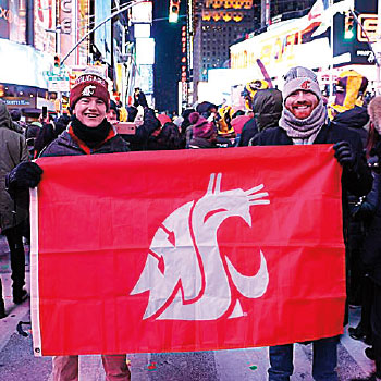 Kevin Schilling in New York City holds a WSU logo flag with a friend.