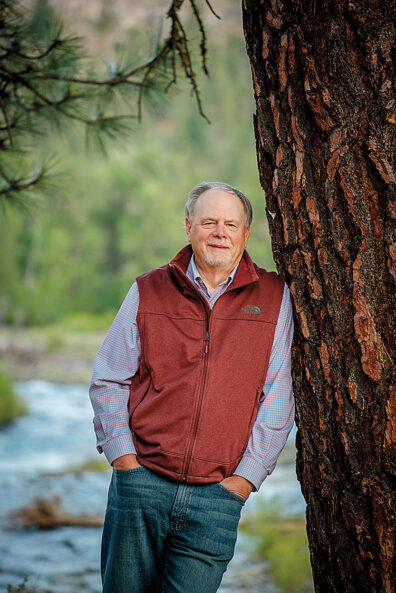 Rob Phillips in fleece vest leans against a tree