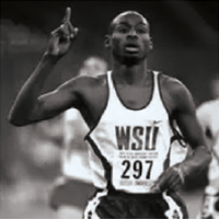 Black‑and‑white photo of a runner wearing a WSU uniform raising one finger