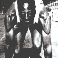 High‑contrast black‑and‑white image of a muscular track sprinter bent forward at the starting position, with arms and legs prominently defined.
